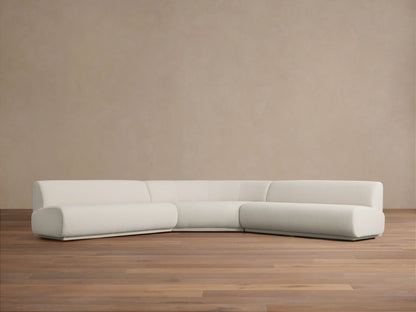 Gianni Three-Piece Corner Sectional in white fabric, featuring a modern, minimalist design. Set on a light wood floor against a beige wall.