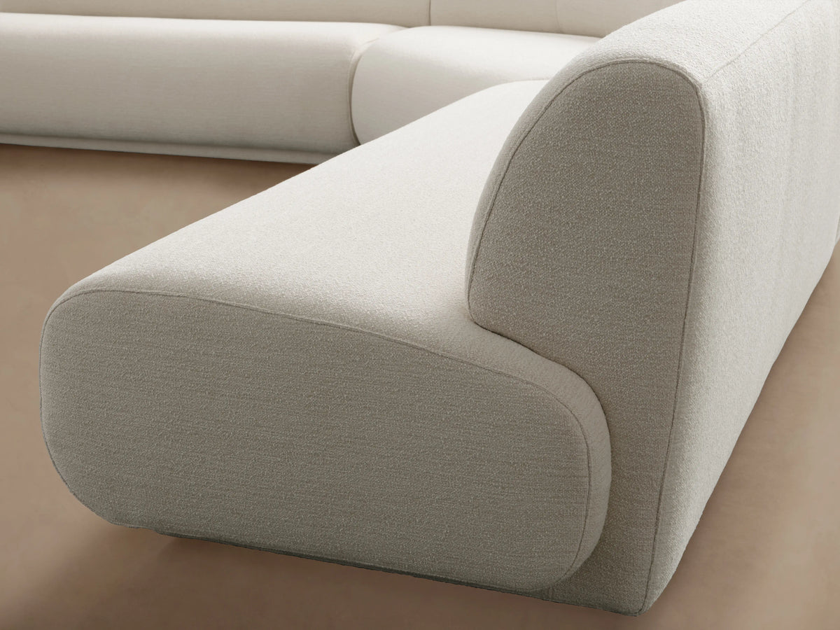 Gianni Three-Piece Corner Sectional in white with smooth cushions, showcasing a sleek design, placed on a wooden floor.