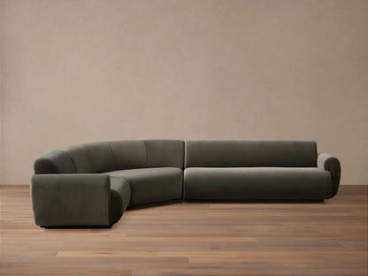 L-shaped Gianni Three-Piece Sectional, dark grey velvet, featuring a curved corner and a straight section with a rolled arm.