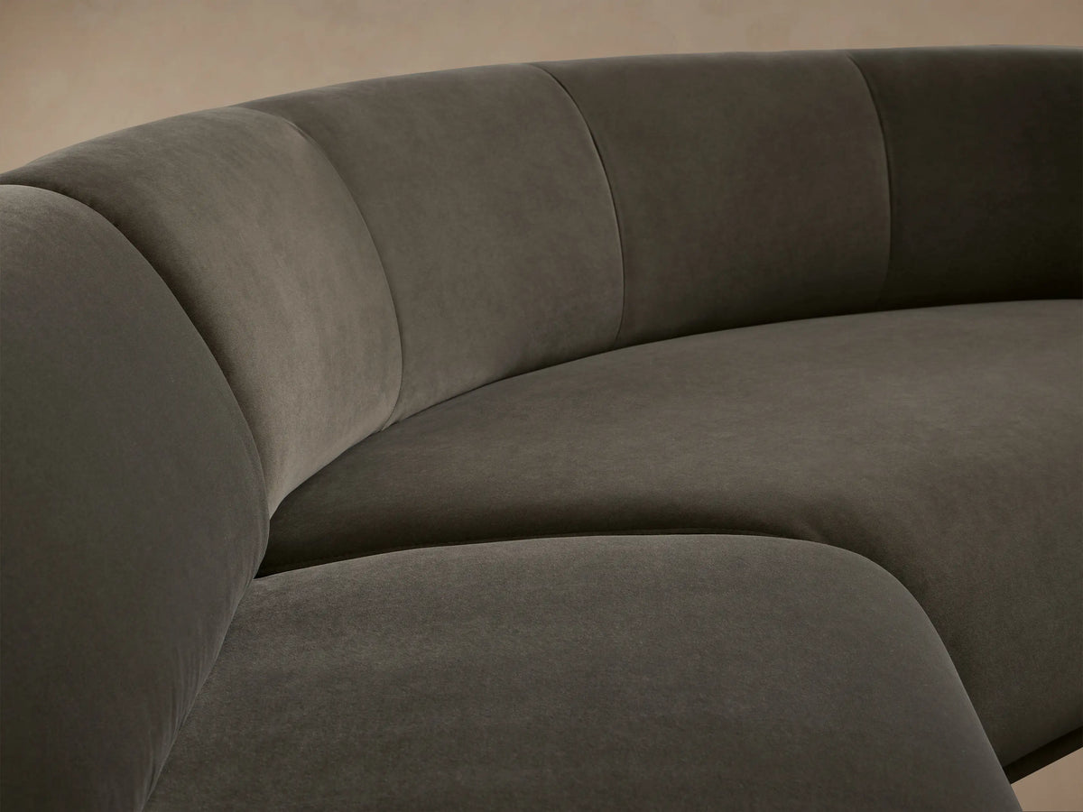 L-shaped Gianni Three-Piece Sectional, dark grey velvet, featuring a curved corner and a straight section with a rolled arm.