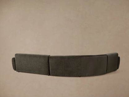 Gianni Three-Piece Sectional, dark green velvet, L-shaped with smooth curved backrests, on wood floor against beige wall.