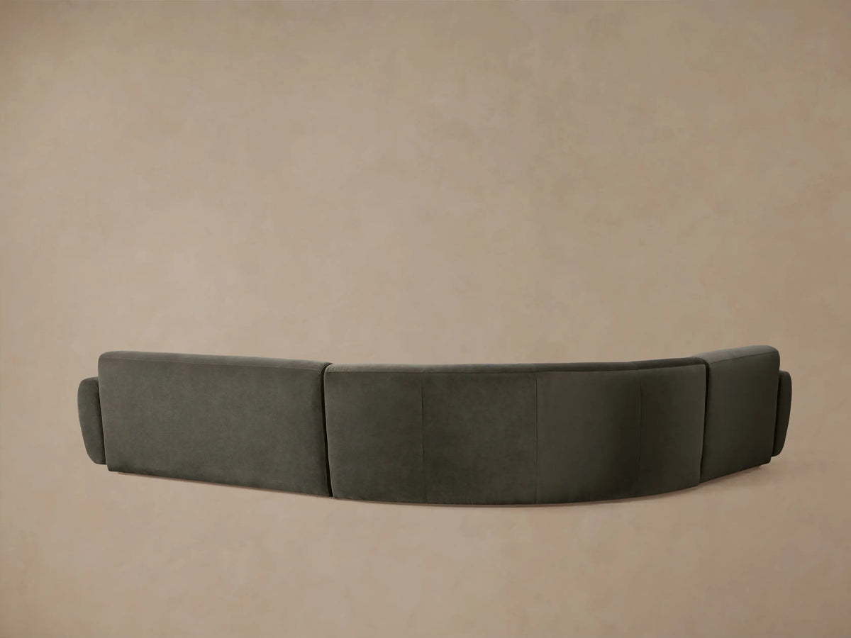 Curved Gianni Three-Piece Sectional in charcoal velvet, featuring plush, rounded backrests and seat cushions.