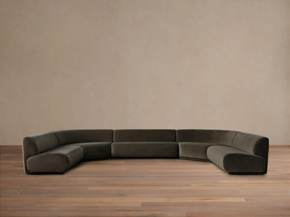 Dark olive green Gianni Five-Piece Armless Curved Sectional in a deep U-shape, resting on a wood floor against a neutral wall.