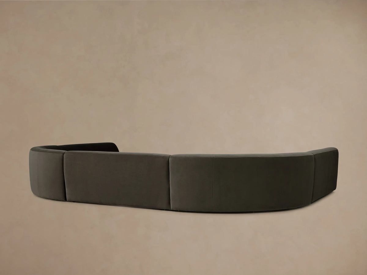 Gianni Armless Curved Sectional in dark charcoal plush fabric, detailed view of a smoothly curved back and rounded seat.