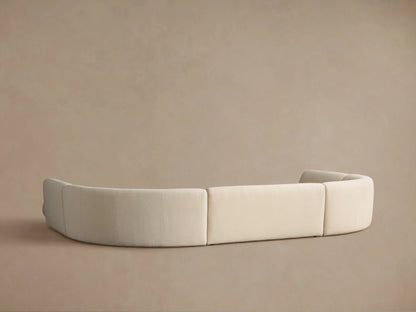 Elevated view of a Gianni Curved Bumper Sectional, light cream, textured fabric, showing its seamless, flowing design.