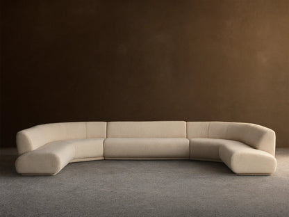 Cream Gianni Five-Piece Curved Bumper Sectional, low-profile and modular, on wood floor against a plain wall.