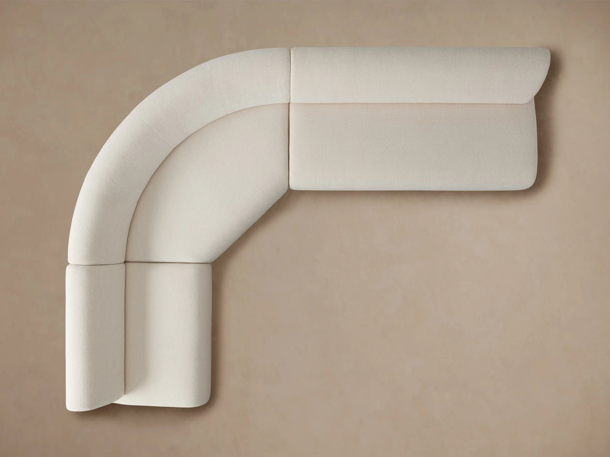 Gianni Three-Piece Sectional in cream fabric shown from the back, highlighting its curved design and smooth upholstery.