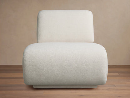Gianni Swivel Chair in a textured, creamy white fabric, shown front-facing. Features a rounded, plush seat and backrest on a wooden floor.