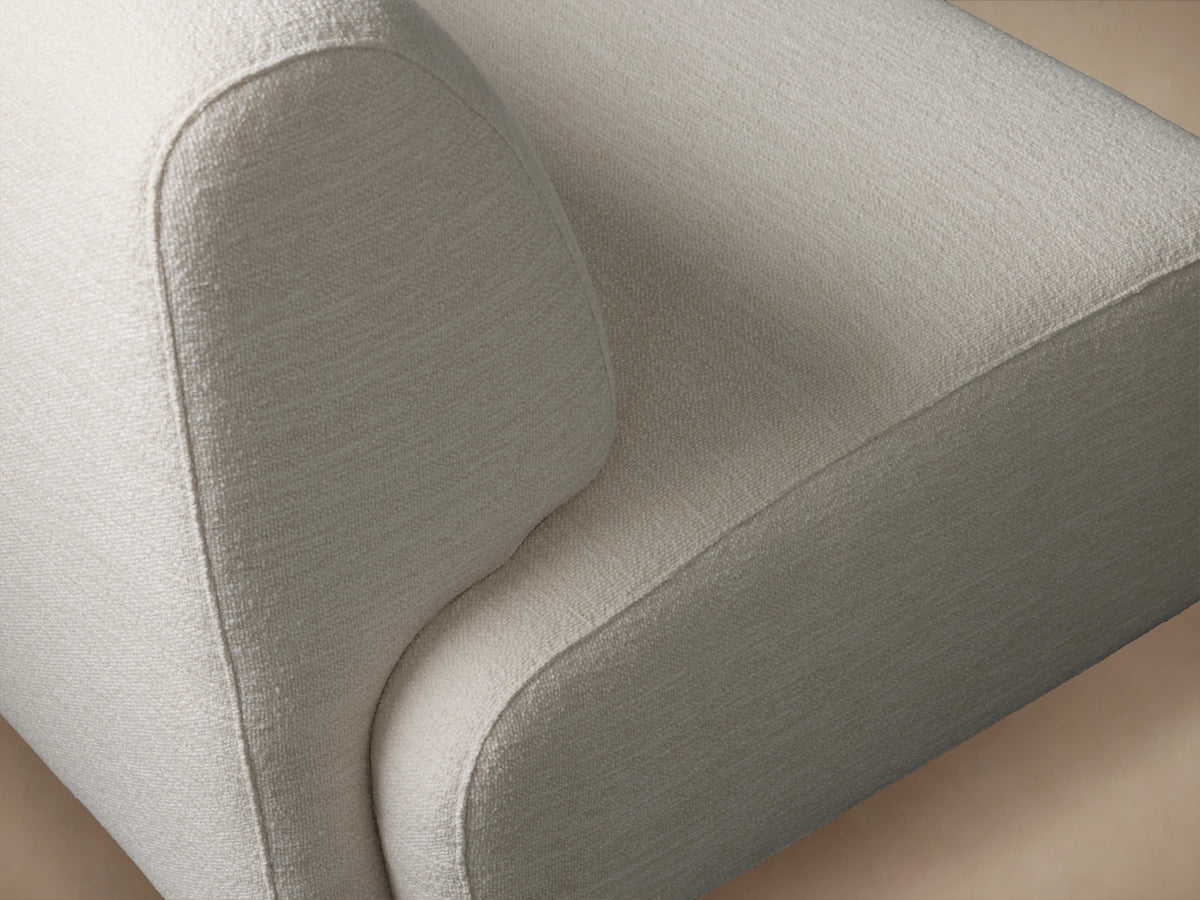 Gianni Swivel Chair with a rounded backrest and seat in light beige fabric. Set on wooden floor, angled to show its curvature.