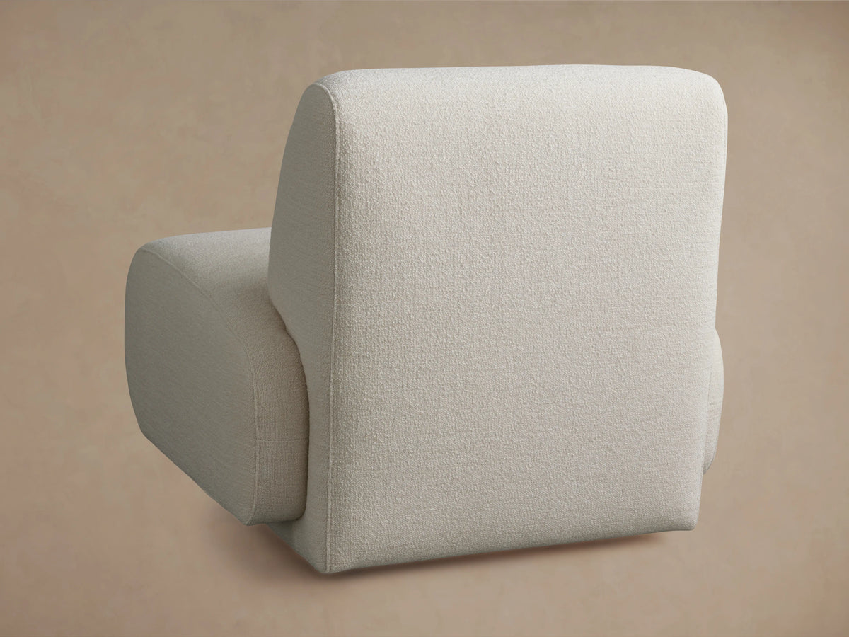 Gianni Swivel Chair in light beige fabric showing a close-up of the armrest and seat cushion with a textured surface.