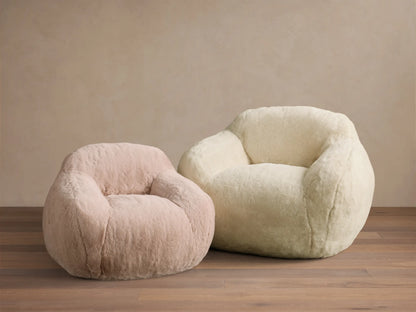 Rear view of the Blush Snugg Faux Fur Kids Chair, showing its soft, rounded back and side profile.
