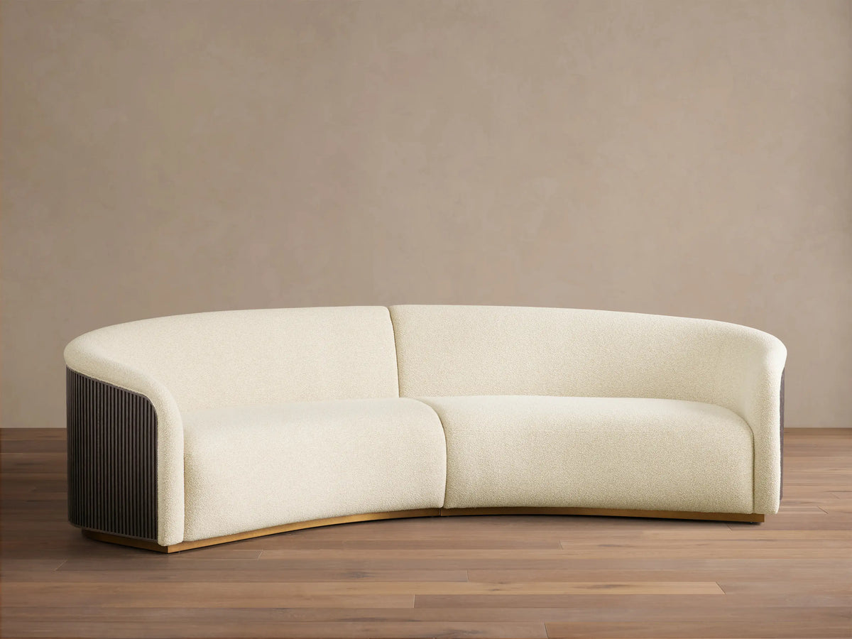 Front view of the cream Finnley Two-Piece Curved Sectional with Ebony slatted wood arms and Honey wood base.