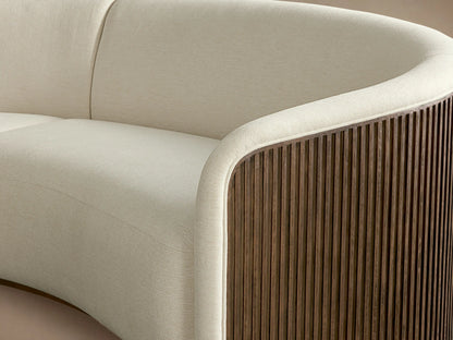 Finnley Two-Piece Curved Sectional in cream fabric, dark wood slatted ends, and light wood base on a wooden floor.