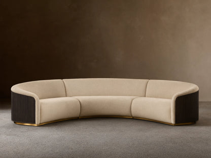 Front view of an Ecru Finnley Three-Piece Curved Sectional with black slatted armrests and a golden base.