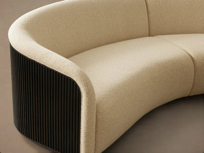 Side profile of the Finnley Three-Piece Curved Sectional with dark fluted back, light cream upholstery, and light wood base.