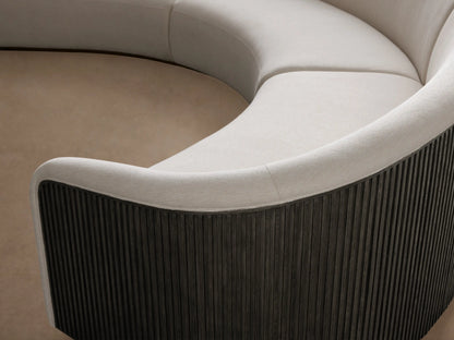 Curved three-piece Finnley sectional with cream-colored upholstery, black ribbed wooden side panels, and light wood flooring.
