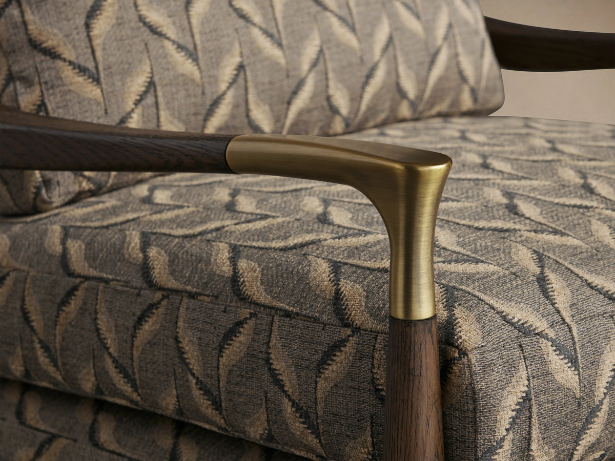 Fisher Chair with mocha wood frame, brass accents, and geometric gray and gold patterned upholstery, front view.