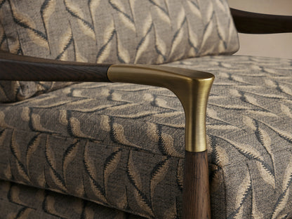 Fisher Chair with mocha wood frame, brass accents, and geometric gray and gold patterned upholstery, front view.