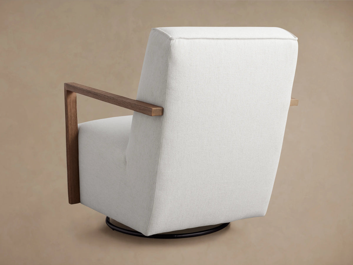 Walsh Glider side view with light gray upholstery, wooden armrests, and a circular base for swivel and glide functions.