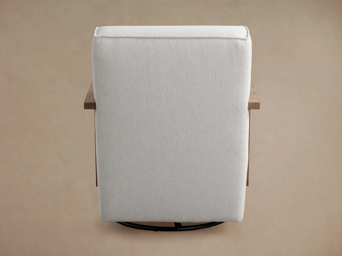 Walsh Glider in light gray fabric with wooden armrests, shown from a rear angle on a brown background. Circular black swivel base visible.