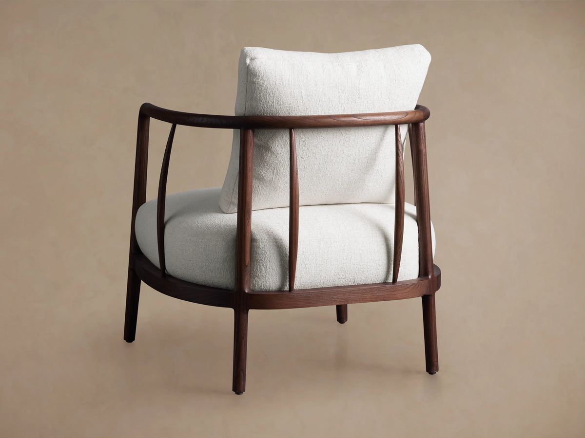 Griggs Chair with curved mahogany frame, rich tone finish, and plush light-colored upholstery, on a neutral background.