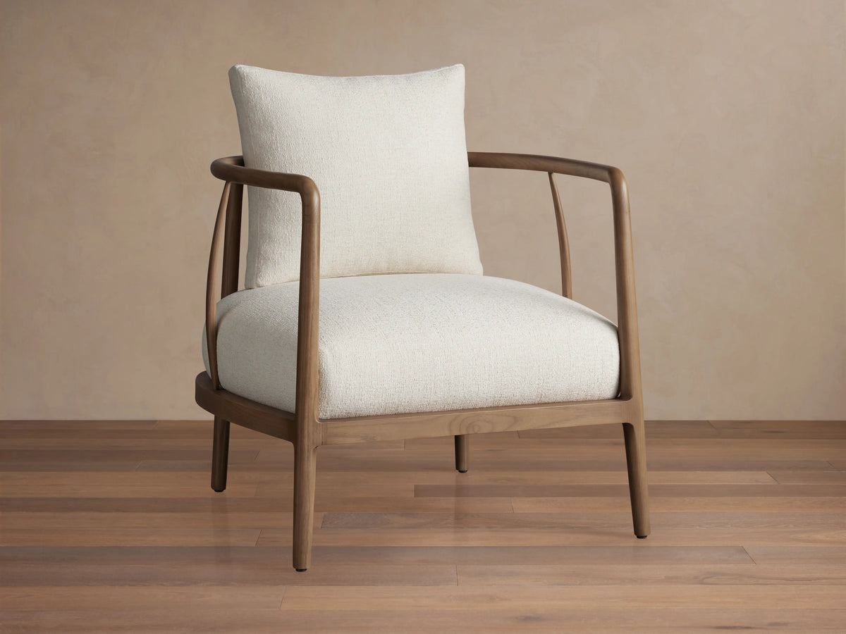 Griggs Chair with a solid mahogany and sungkai wood frame in rich tones, features light-colored plush upholstery and generous cushioning.