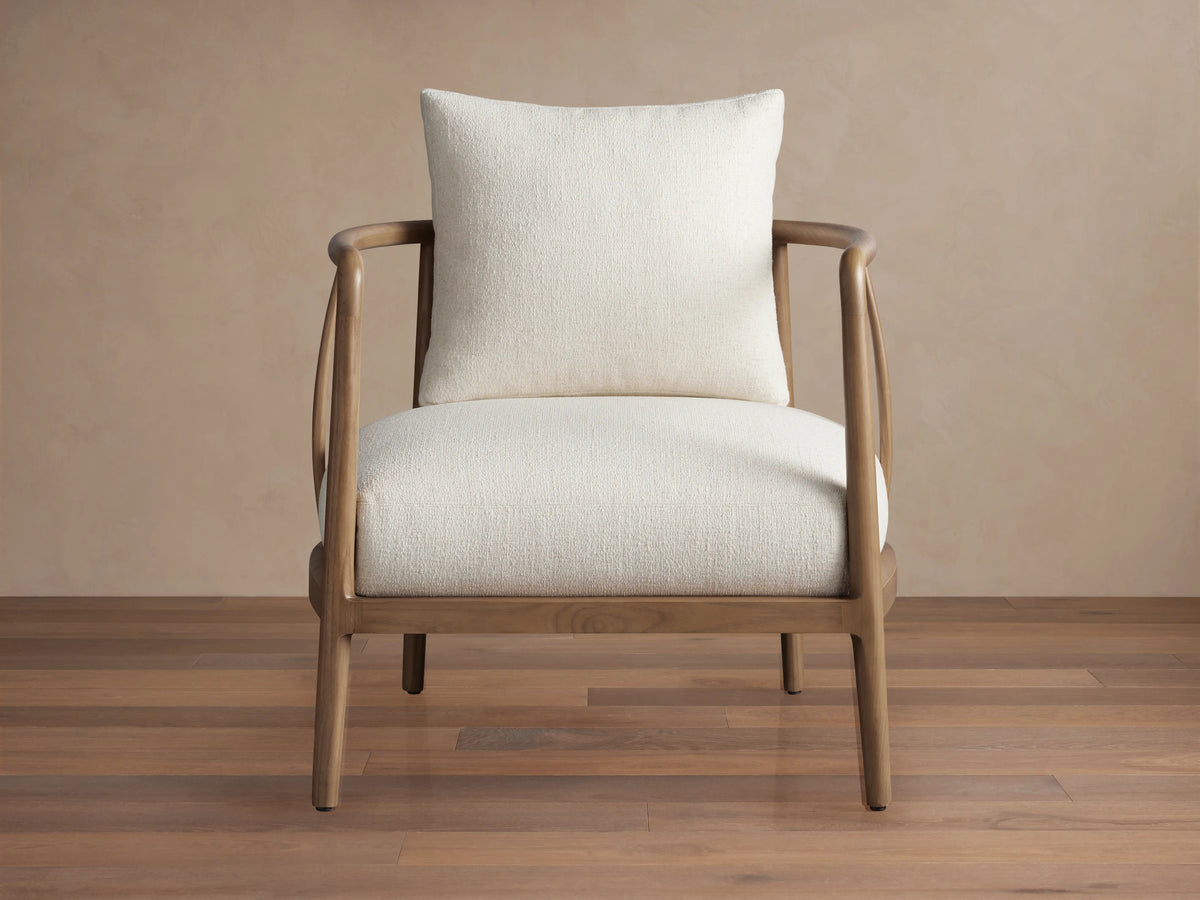 Griggs Chair with a solid mahogany and sungkai wood frame in rich tones, features light-colored plush upholstery and generous cushioning.