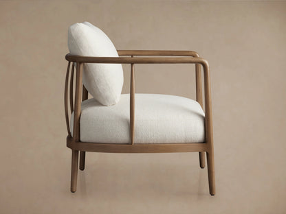 Griggs Chair featuring light-colored plush upholstery on a curved wood frame with a smooth, natural finish.
