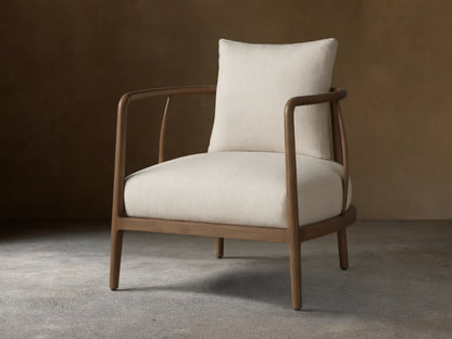 Griggs Chair with a solid mahogany and sungkai wood frame in rich tones, features light-colored plush upholstery and generous cushioning.