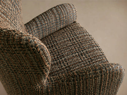 Gemma Swivel Chair with a high backrest and wide armrests upholstered in a textured, multicolored fabric, on a wooden floor.
