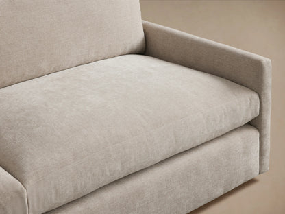Kipton Two-Piece Sectional in neutral beige fabric on a wooden floor. The sectional has squared armrests and plush seat cushions with a backrest.