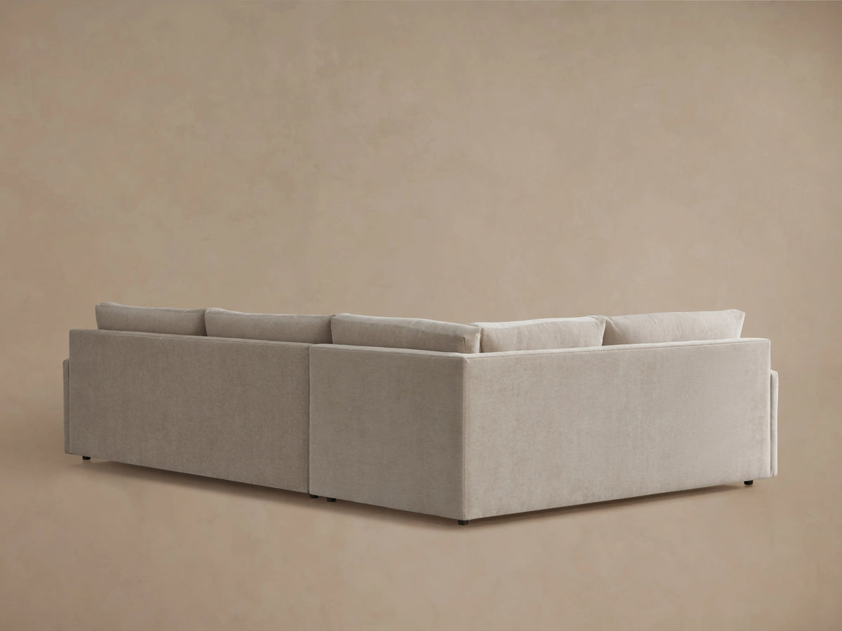 Kipton Two-Piece Sectional in beige fabric showing a plush seat cushion and armrest. The fabric has a soft, textured appearance.