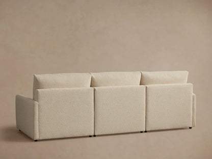 Beige Kipton Three-Piece Motion Modular Sofa with slim arms. Close-up of cushioned seat and backrest. Button control on arm.