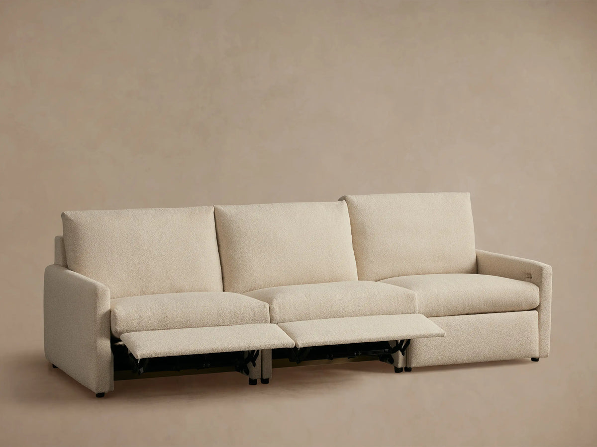 Kipton Three-Piece Motion Modular Sofa in beige, shown from the back. Features slim arms and a three-section design on a beige background.