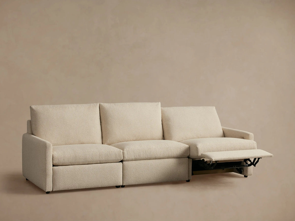 Kipton Three-Piece Motion Modular Sofa in beige fabric with two extended footrests and slim arms, set against a neutral background.
