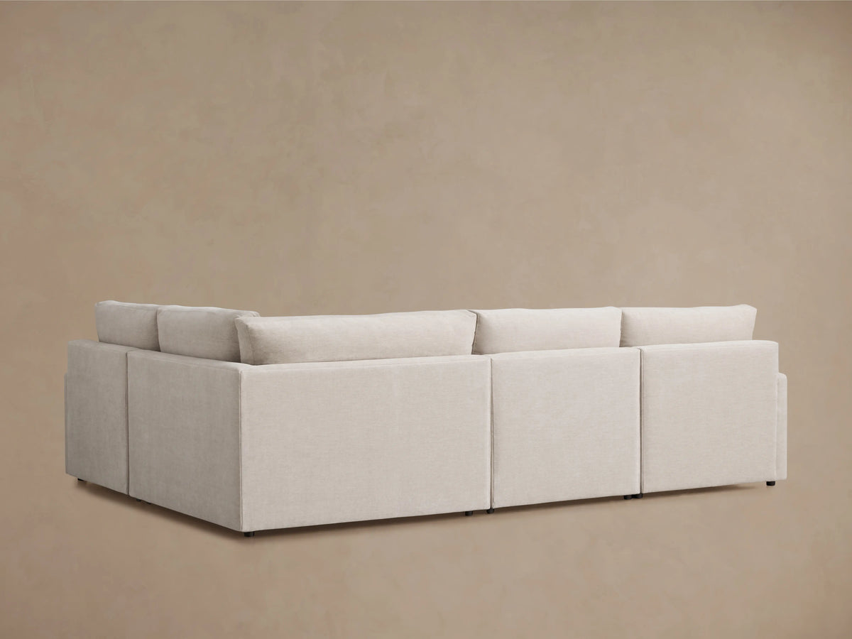 Kipton Four-Piece Motion Sectional in light gray fabric, showing extended footrest and reclining feature. Slim arm design with sleek finish.