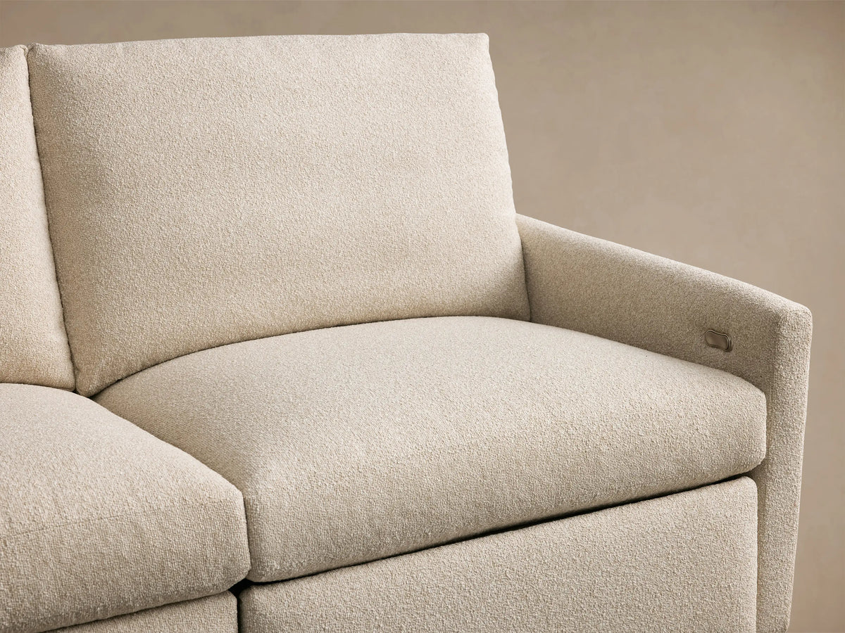 Kipton Four-Piece Motion Modular Sofa in beige fabric, featuring a textured surface and a sleek silver two-button control on the armrest.