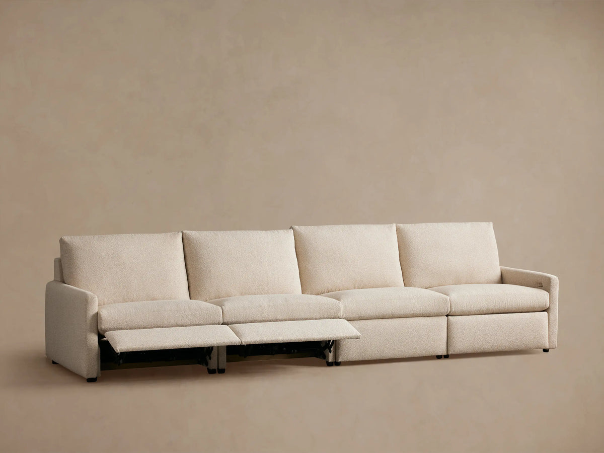 Kipton Four-Piece Motion Modular Sofa shown from the back, featuring light beige upholstery and slim arm design.