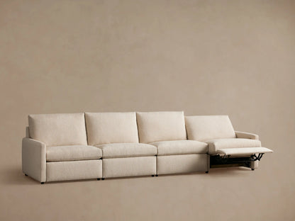 Four-piece beige modular sofa with slim arms, one section reclined with visible metal supports, set against a neutral background.