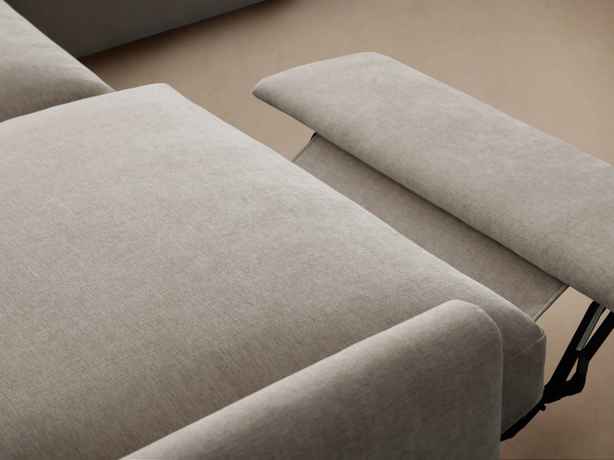 Kipton Four-Piece Motion Sectional in a light beige fabric, forming an L-shape. Slim arms, plush cushions on hardwood floor.