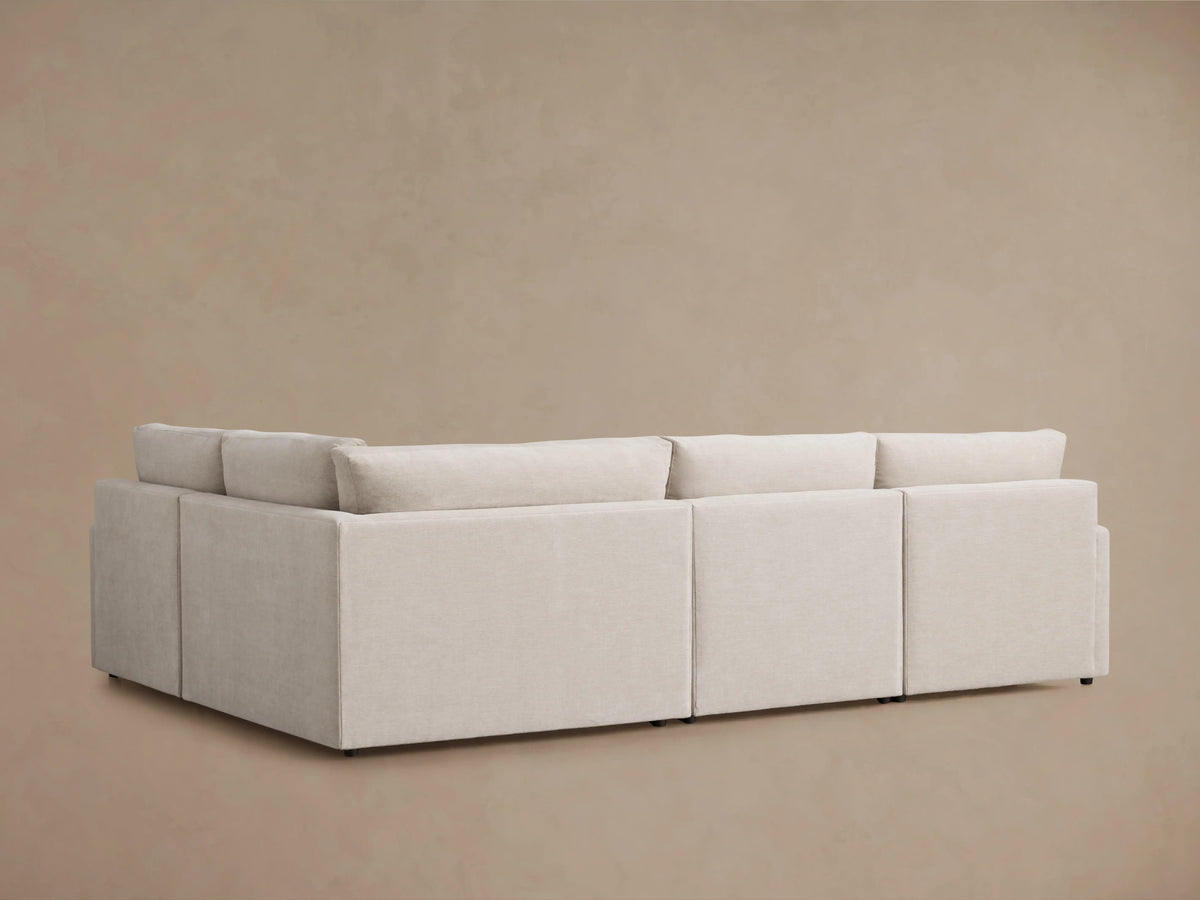 Kipton Four-Piece Motion Sectional with a smooth, light grey fabric. Close-up shows partially reclined footrest, sleek design.