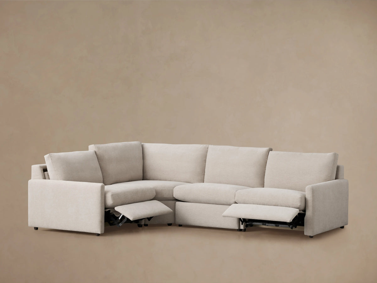 Beige Kipton four-piece motion sectional with slim arms, slightly reclined right end seat, on light brown background.