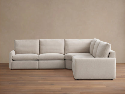 Kipton Five-Piece Motion Corner Sectional in beige fabric on wooden floor, featuring slim arms and plush backrests.