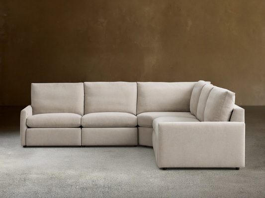 Kipton Five-Piece Motion Corner Sectional in beige fabric on wooden floor, featuring slim arms and plush backrests.