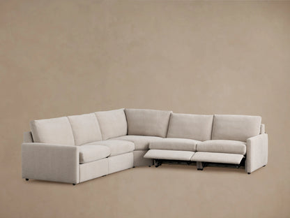 Kipton Five-Piece Motion Corner Sectional in light beige fabric, showing L-shaped design with one reclined seat and slim arms on a plain background.