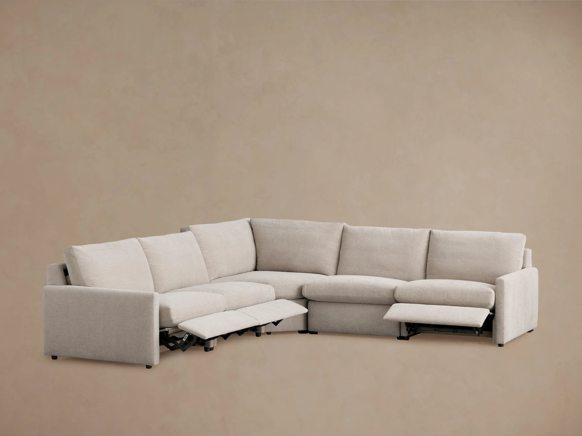 Beige Kipton Five-Piece Motion Corner Sectional with slim arms and two extended footrests, set against a neutral background.