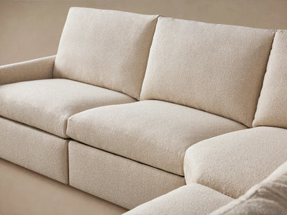 Close-up of the Kipton Six-Piece Motion Sectional's slim arm in textured beige fabric, featuring a two-button motion control.