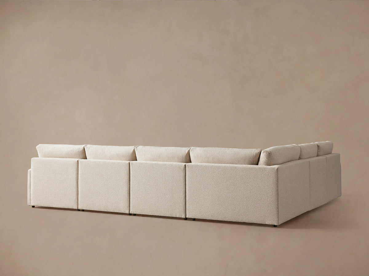 Kipton Six-Piece Motion Sectional in beige fabric with slim arms and plush cushions, arranged in an L-shape on a neutral background.