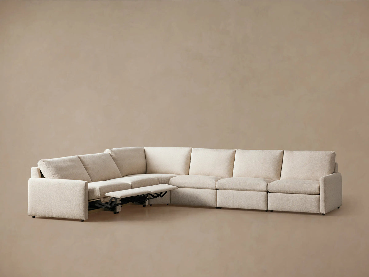 Kipton Six-Piece Motion Sectional in light beige fabric, L-shaped, with three seats reclined and slim arms, on a neutral background.