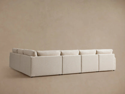 Close-up of Kipton Slim Arm Motion Sectional in light beige textured boucle fabric, with a brushed metal motion button.